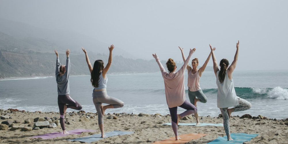 five woman standing on seashore